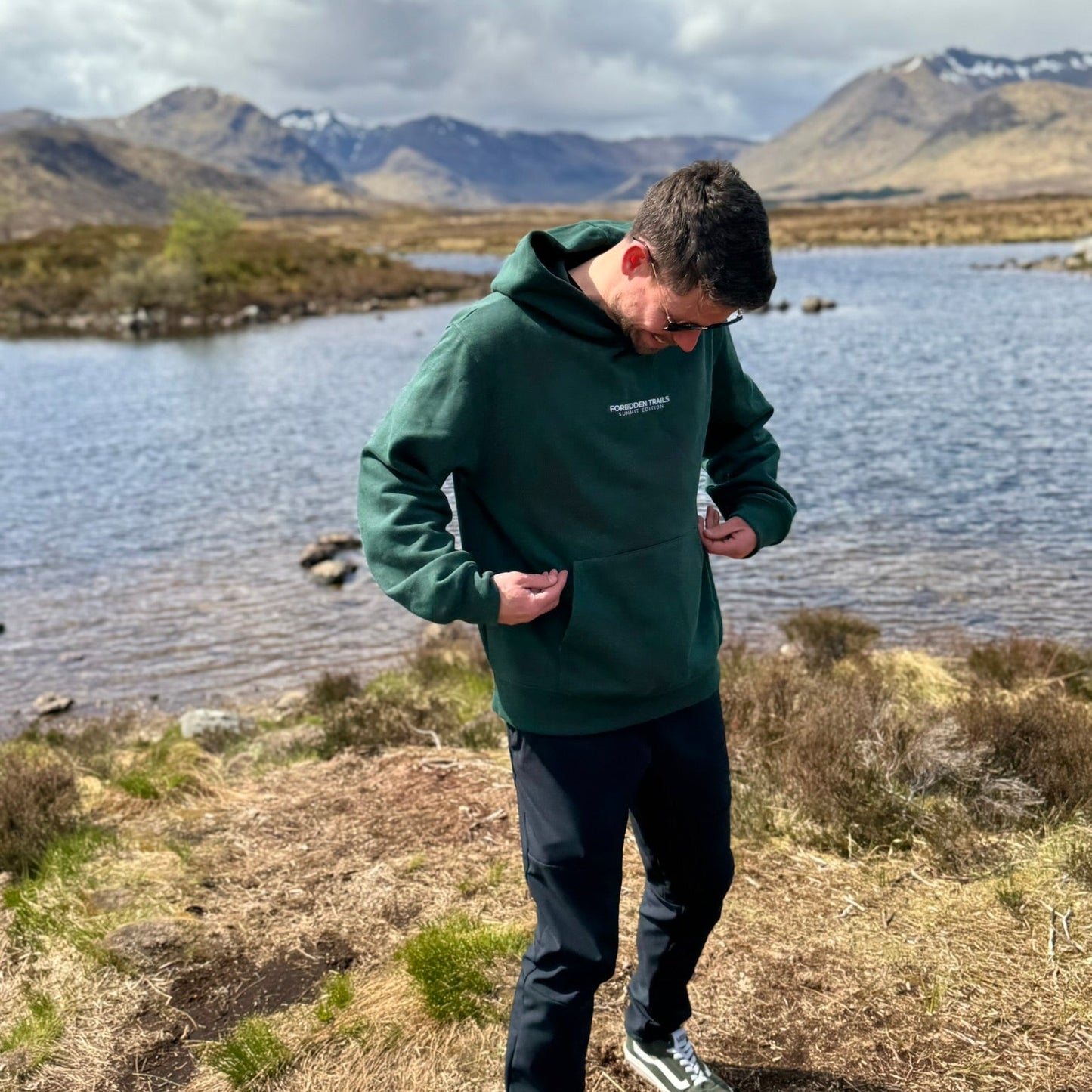 man wearing a green hoodie in the mountains