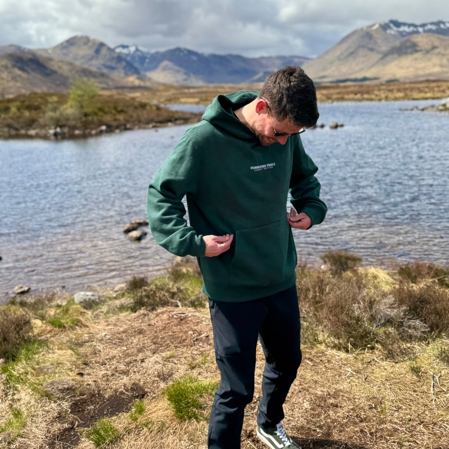 man wearing a green hoodie in the mountains 