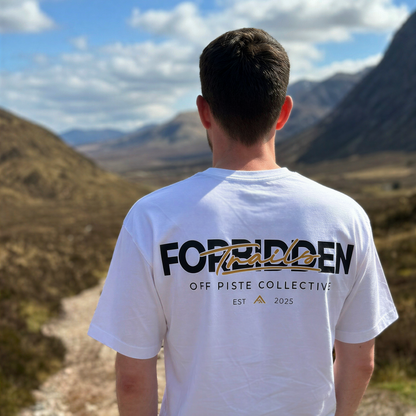 Person wearing a white t-shirt with text standing in a mountainous landscape