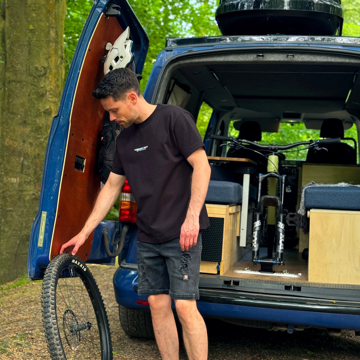 Man unloading a bike from inside a campervan