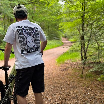 Person walking with a bicycle on a forest path