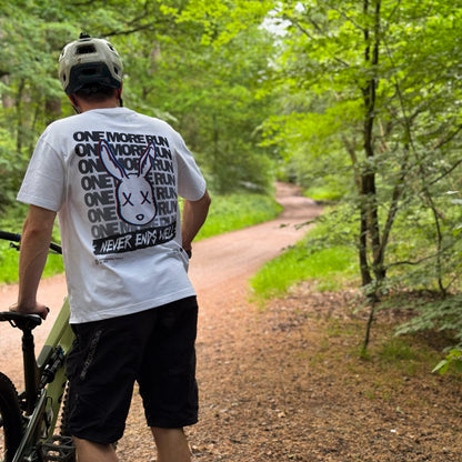 Person walking with a bicycle on a forest path