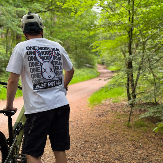 Person walking with a bicycle on a forest path
