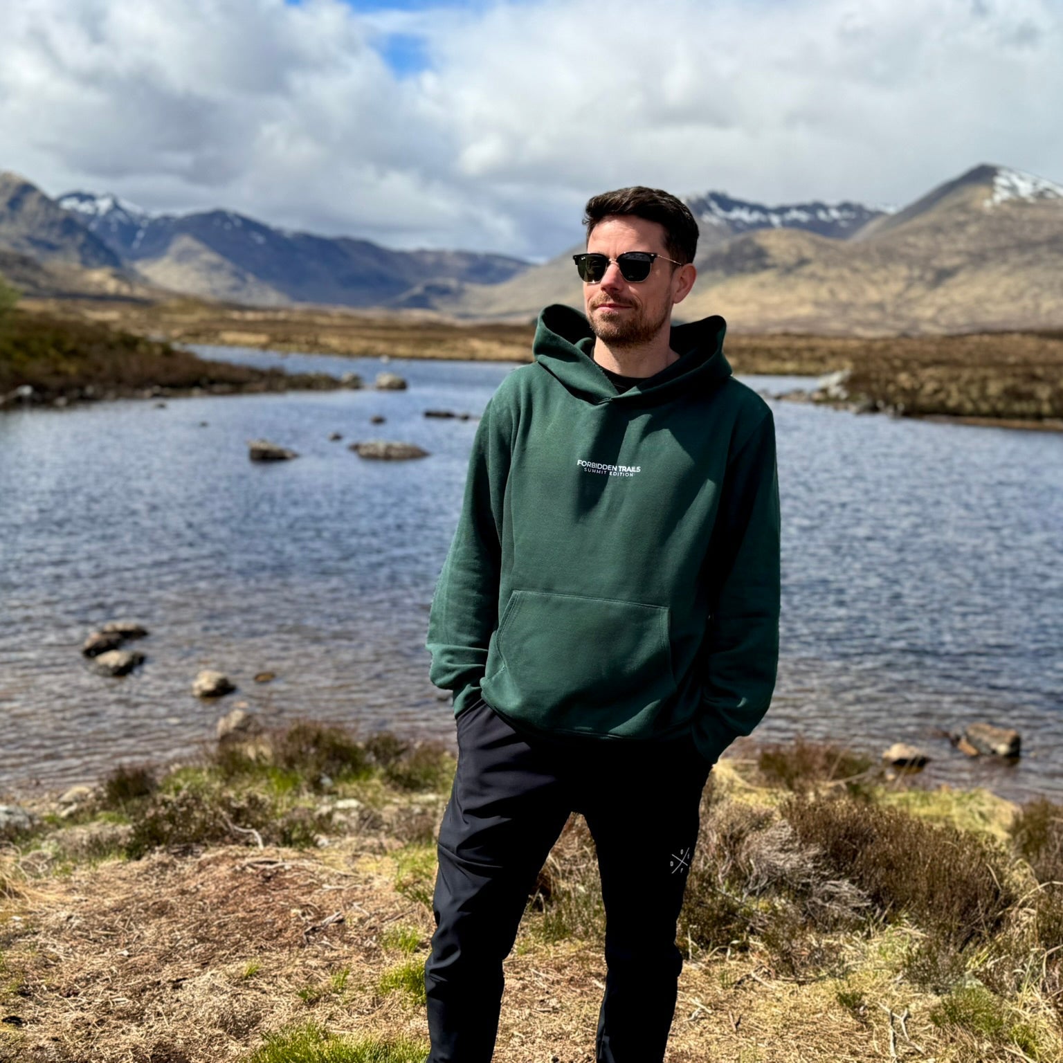 man wearing a green hoodie in the mountains